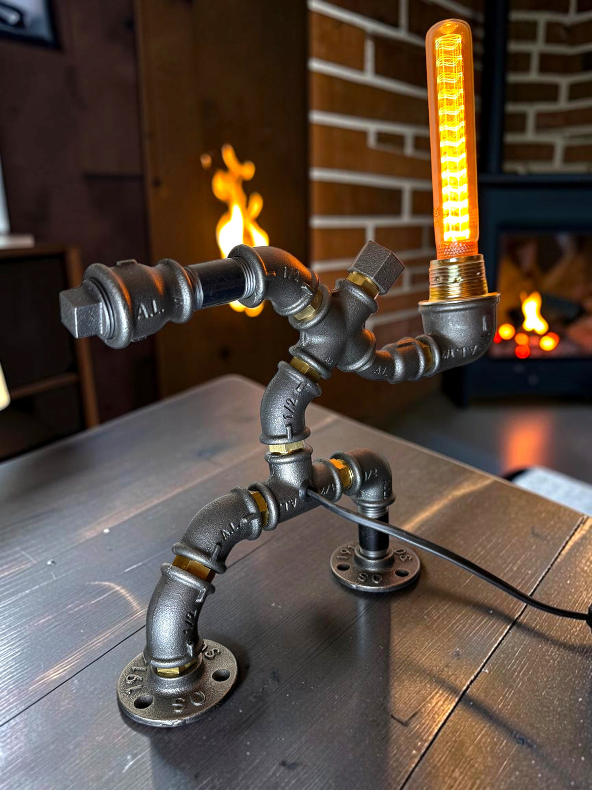 KerleKiste Hampelmann Tischleuchte aus schwarzem Industrierohr mit leuchtender Edison-Glühbirne im Vintage-Stil